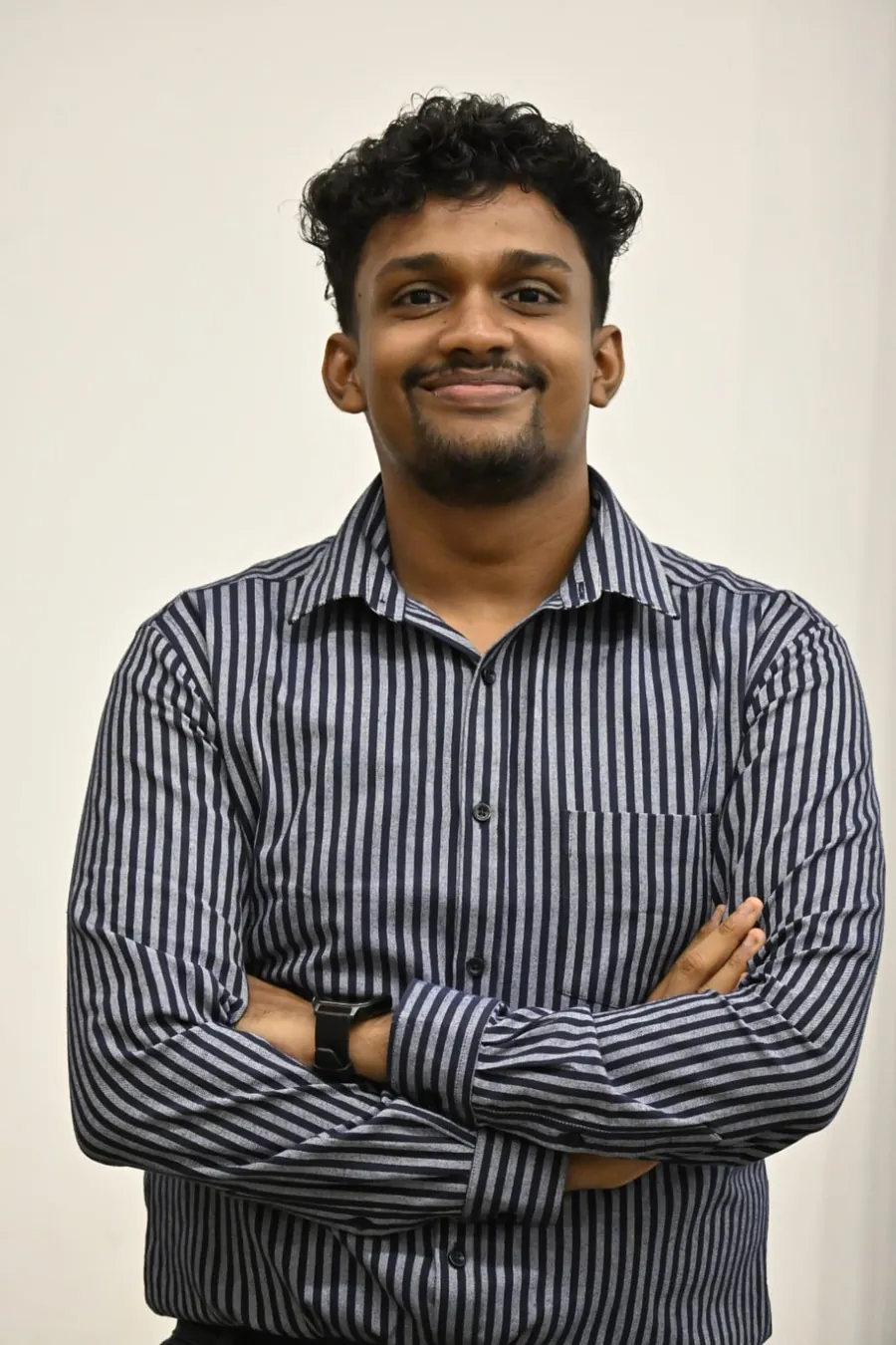 Nimuthu smiling with arms crossed